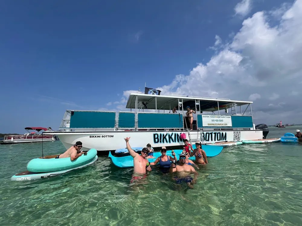The Bikini Bottom double-decker with a group floating on rafts in the shallows