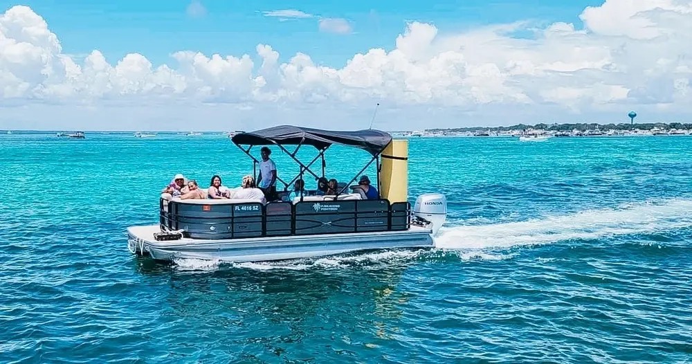 A pontoon with a bimini top underway on emerald water